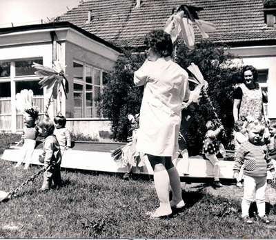 Czarno-białe zdjęcie dziecka na tle Domu Korczaka z lat 70-tych
